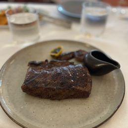 Georgie by Curtis Stone signature dishes Various cuts of premium steaks (e.g., Wagyu, Dry-Aged), House-Made Charcuterie, Seasonal Seafood Preparations, Caviar Service.